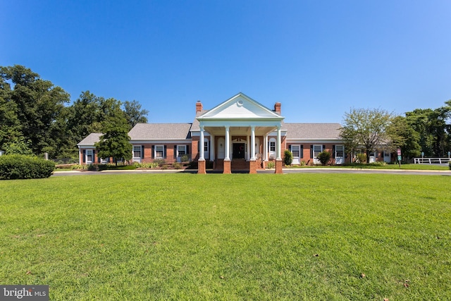 greek revival house featuring a front lawn and a chimney