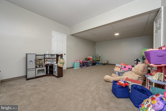 playroom with carpet, baseboards, and a drop ceiling