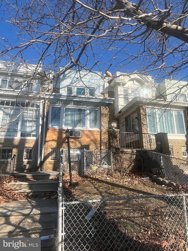 view of front facade with brick siding and a fenced front yard