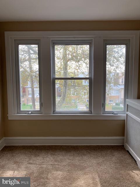 interior details featuring radiator heating unit, carpet, and baseboards