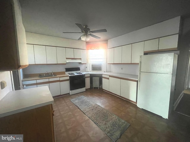 kitchen with white appliances, under cabinet range hood, light countertops, and dark floors