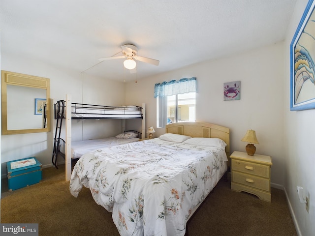 bedroom featuring baseboards, dark colored carpet, and a ceiling fan