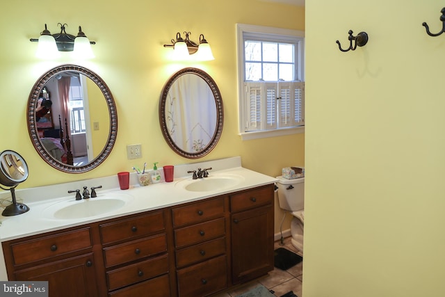 full bath featuring tile patterned flooring, double vanity, toilet, and a sink