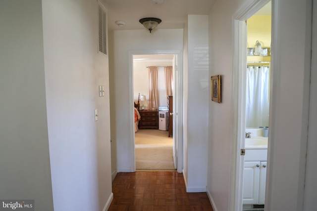 corridor featuring visible vents and baseboards