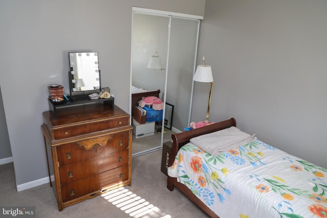 carpeted bedroom featuring a closet and baseboards