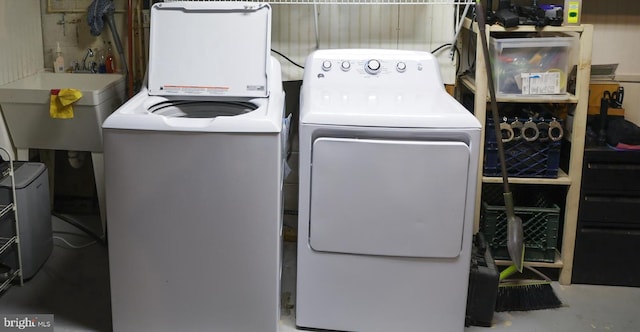 laundry area with washing machine and clothes dryer, laundry area, and a sink