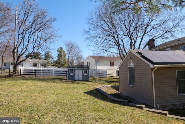 view of yard featuring a fenced backyard, a storage shed, and an outdoor structure