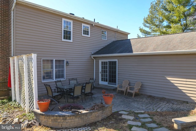 back of property featuring a patio, brick siding, and a shingled roof