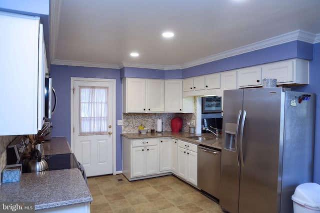 kitchen with light stone countertops, ornamental molding, a sink, white cabinets, and appliances with stainless steel finishes