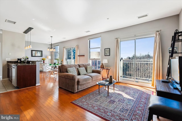 living room featuring a chandelier, visible vents, and hardwood / wood-style floors