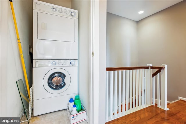 washroom with laundry area, baseboards, stacked washer / dryer, and recessed lighting