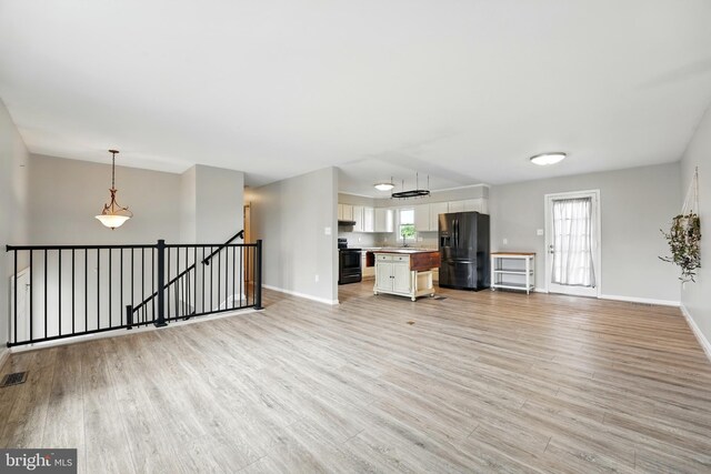 6254 Goulding Ct, Bealeton, VA 22712 - unfurnished living room featuring baseboards, light wood-style flooring, and a sink