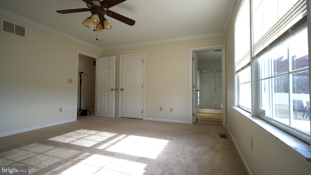 unfurnished bedroom featuring baseboards, visible vents, crown molding, and light colored carpet