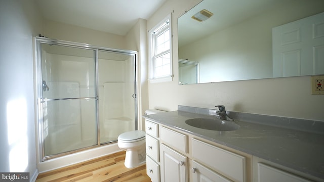 full bathroom featuring vanity, wood finished floors, a shower stall, and toilet