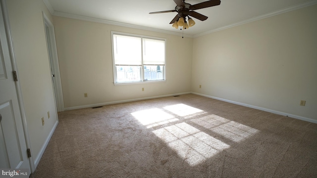 spare room featuring light colored carpet, crown molding, visible vents, and baseboards