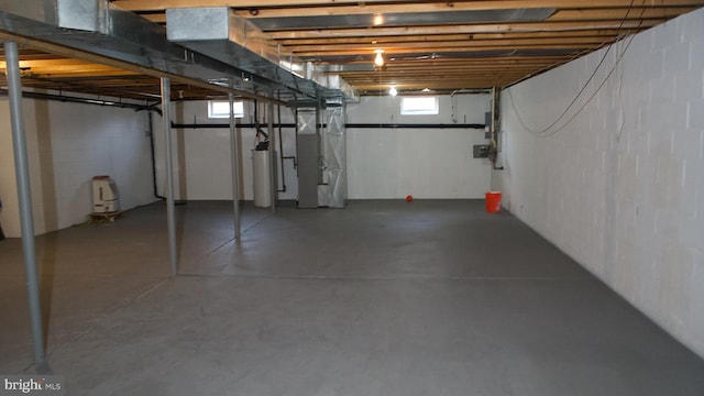 basement featuring gas water heater and heating unit