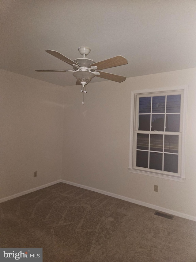 carpeted empty room featuring visible vents, ceiling fan, and baseboards