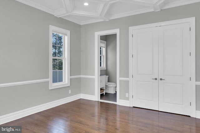unfurnished bedroom featuring coffered ceiling, ensuite bathroom, baseboards, a closet, and wood finished floors