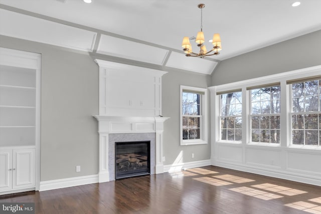 unfurnished living room featuring a chandelier, baseboards, lofted ceiling, dark wood-style floors, and a glass covered fireplace