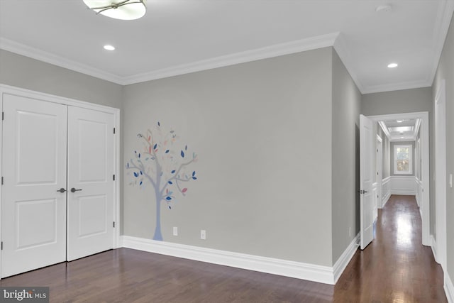 unfurnished bedroom with baseboards, a closet, ornamental molding, and dark wood-type flooring