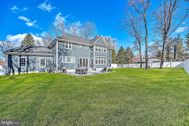 rear view of property with a fenced backyard, central AC unit, a yard, and a patio area