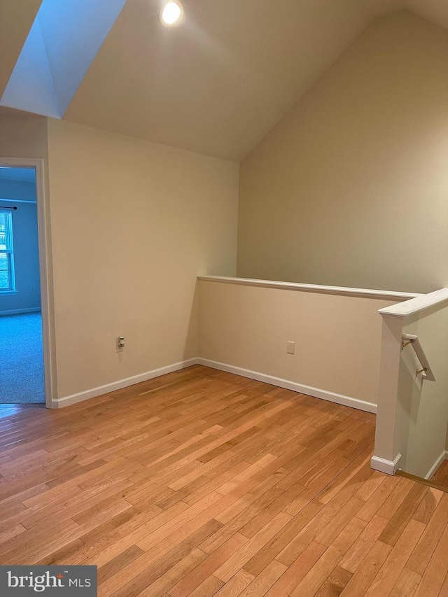 interior space with lofted ceiling, light wood finished floors, and baseboards