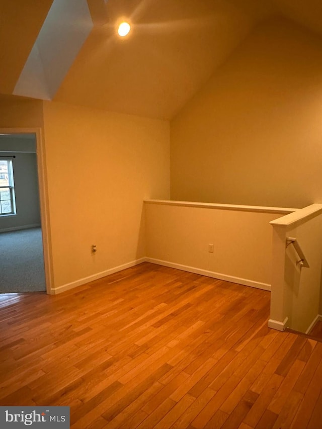 bonus room with lofted ceiling, baseboards, and wood finished floors