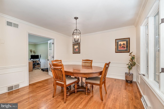 dining room with ornamental molding, visible vents, and light wood-style floors