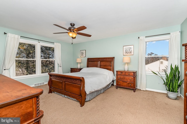 carpeted bedroom featuring a ceiling fan, visible vents, and baseboards