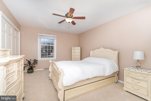 bedroom with light carpet, baseboards, visible vents, a ceiling fan, and a closet