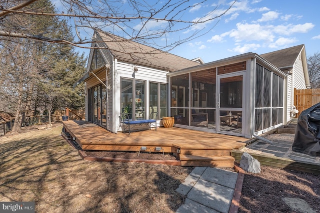 back of property featuring a sunroom, fence, and a deck