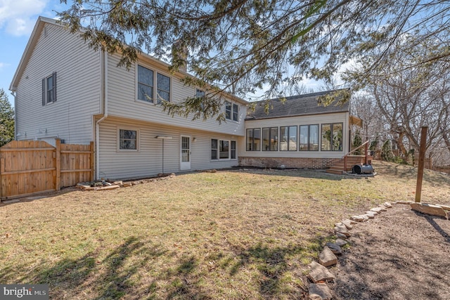 back of property featuring a yard, a chimney, fence, and a sunroom