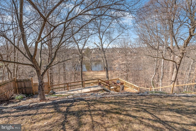 view of yard with fence and a view of trees