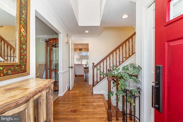 entrance foyer featuring recessed lighting, crown molding, stairway, and wood finished floors