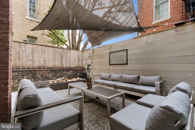 view of patio with an outdoor living space and fence