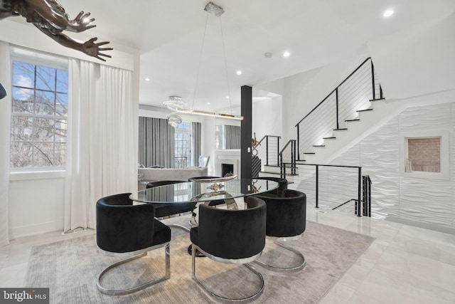 dining space with a fireplace, stairway, recessed lighting, and a healthy amount of sunlight