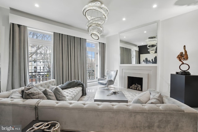 living room with recessed lighting, plenty of natural light, a chandelier, and a fireplace