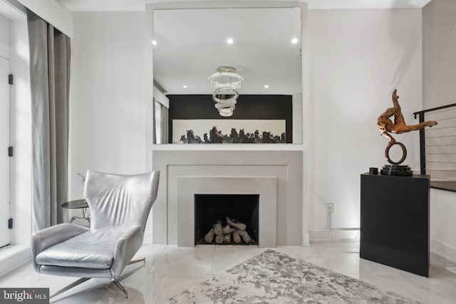 living area featuring a chandelier, stairway, and a fireplace