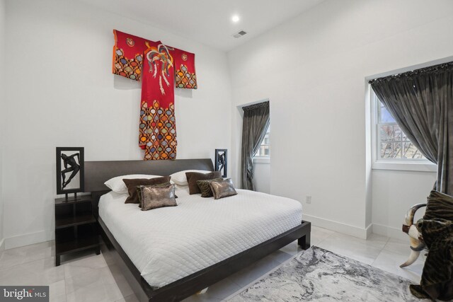 bedroom featuring baseboards, multiple windows, and visible vents