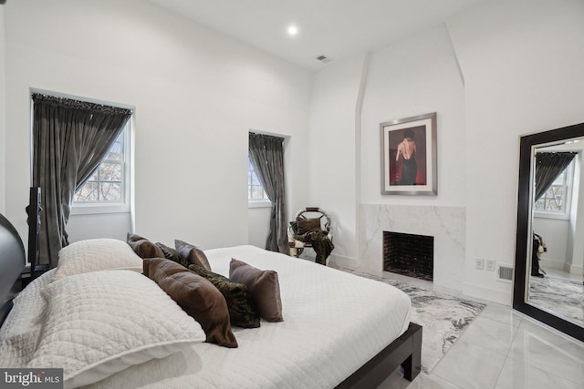 bedroom with recessed lighting, visible vents, multiple windows, and a high end fireplace