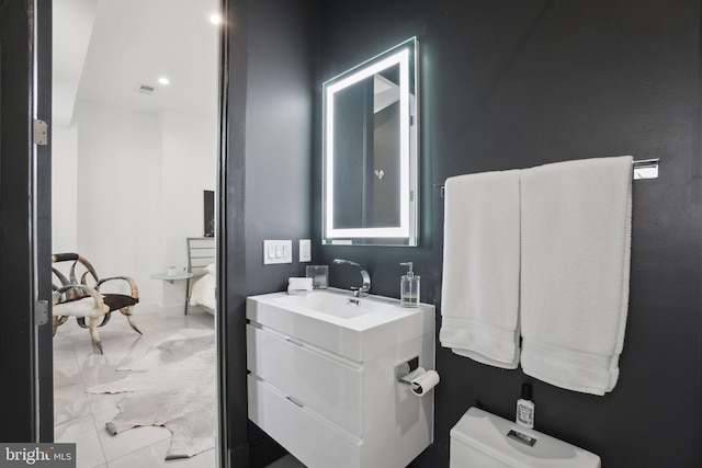 ensuite bathroom featuring visible vents, toilet, marble finish floor, connected bathroom, and vanity