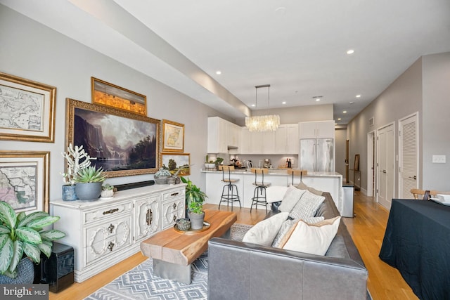 living room featuring recessed lighting, light wood-style flooring, and baseboards