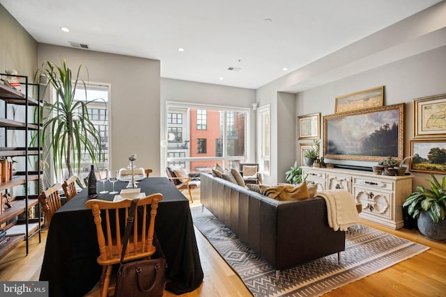 living room featuring light wood-style flooring, visible vents, and recessed lighting