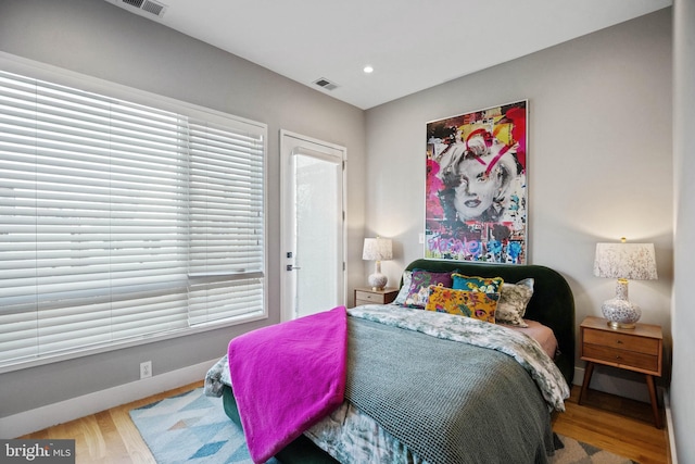 bedroom with recessed lighting, visible vents, baseboards, and wood finished floors