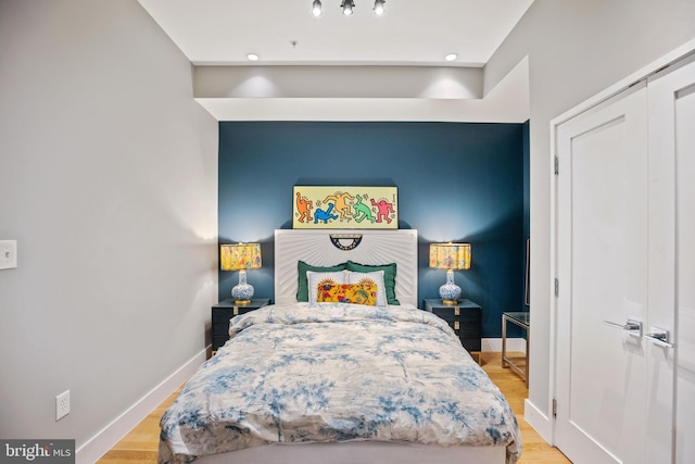 bedroom featuring light wood-type flooring and baseboards