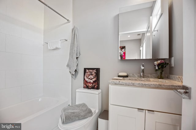 bathroom with washtub / shower combination, vanity, and toilet