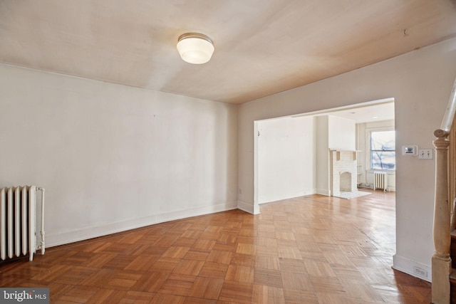 spare room with radiator and baseboards