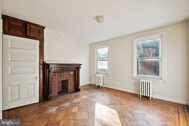 unfurnished living room with radiator, baseboards, and a tile fireplace