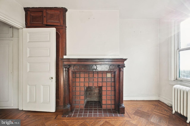 details with radiator, baseboards, and a tiled fireplace