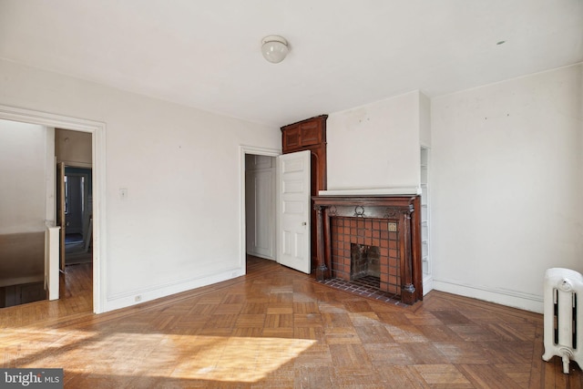 unfurnished living room with baseboards, a fireplace, and radiator heating unit